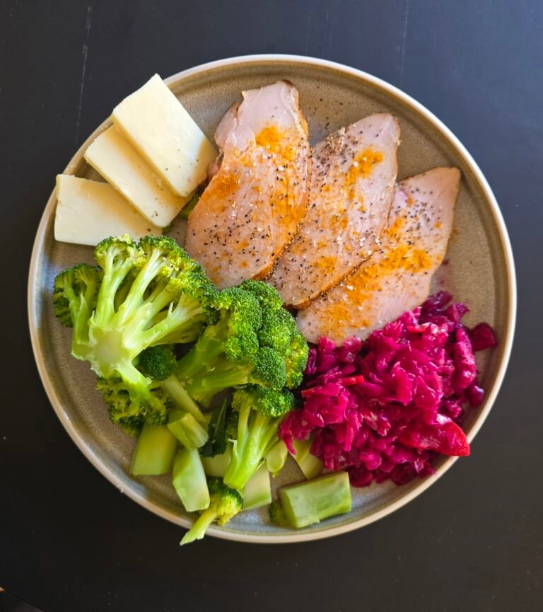 Sliced turkey, broccoli, cheese and cabbage on a plate