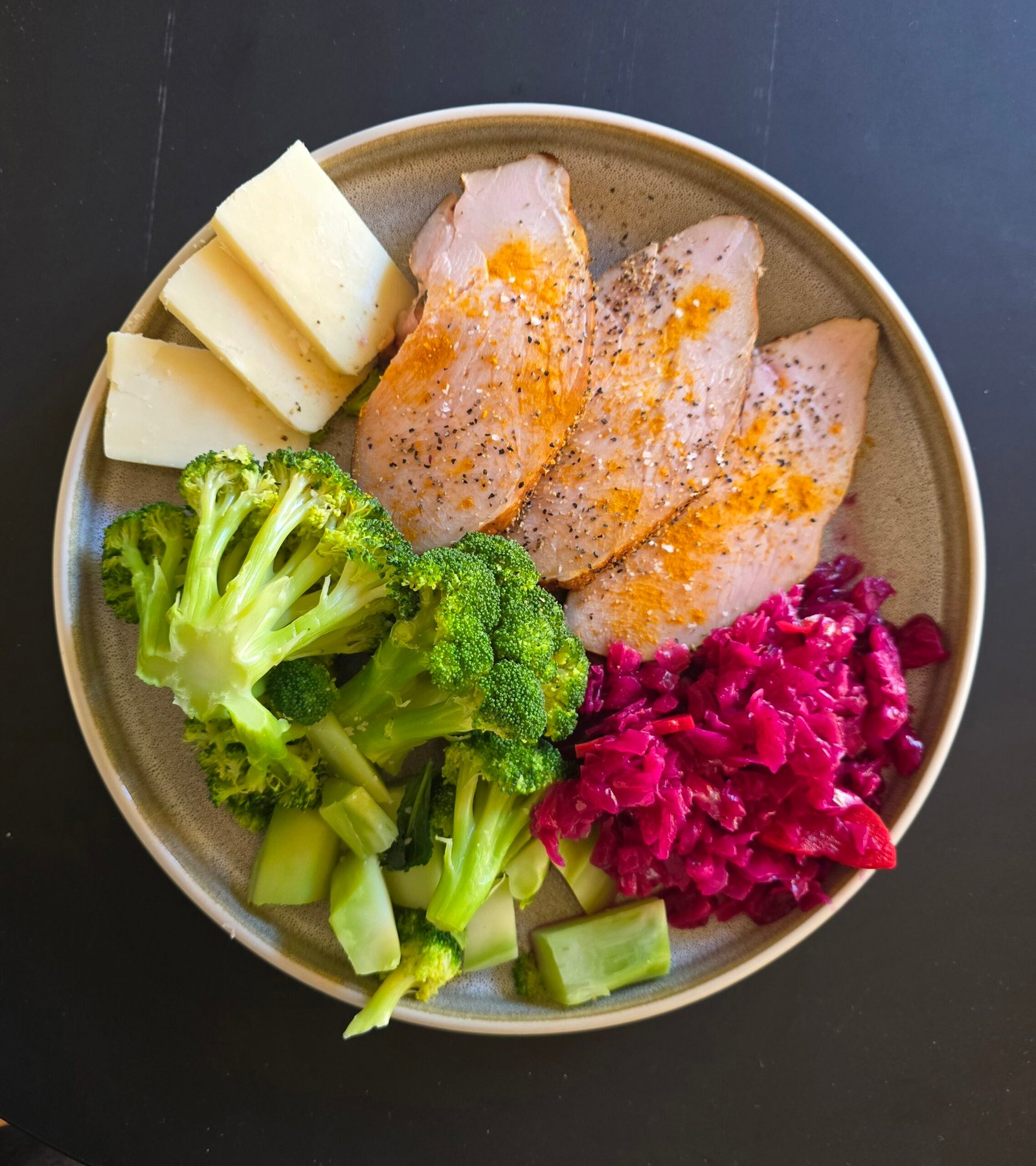 Sliced turkey, broccoli, cheese and cabbage on a plate