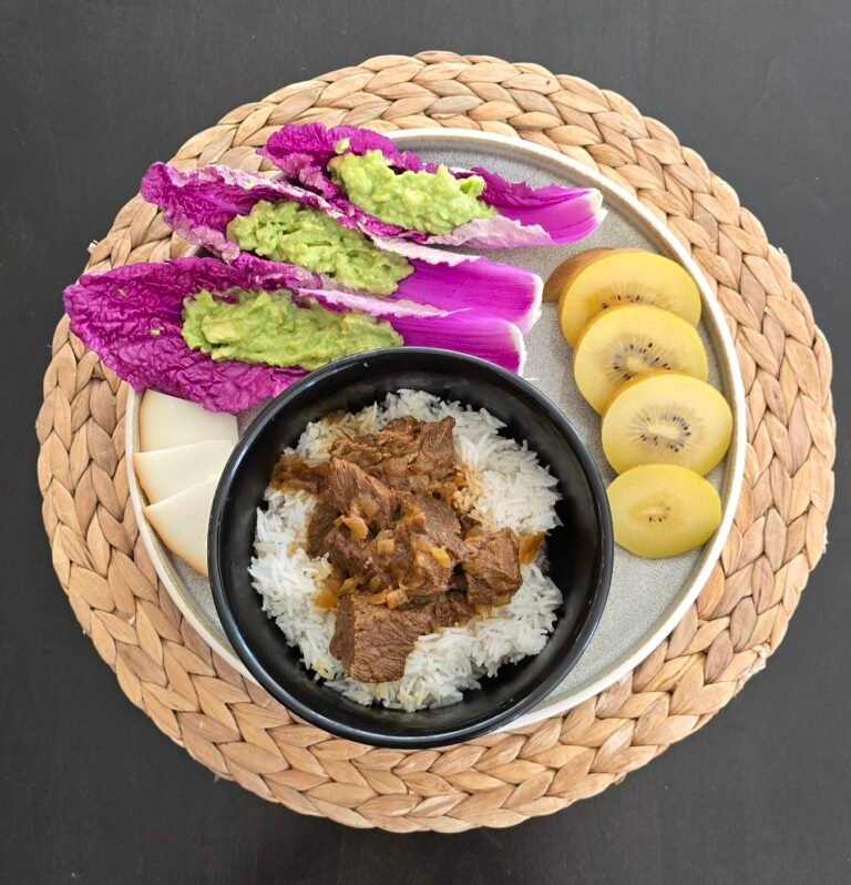 Beef stew on rice with pink napa cabbage, guacamole and kiwi